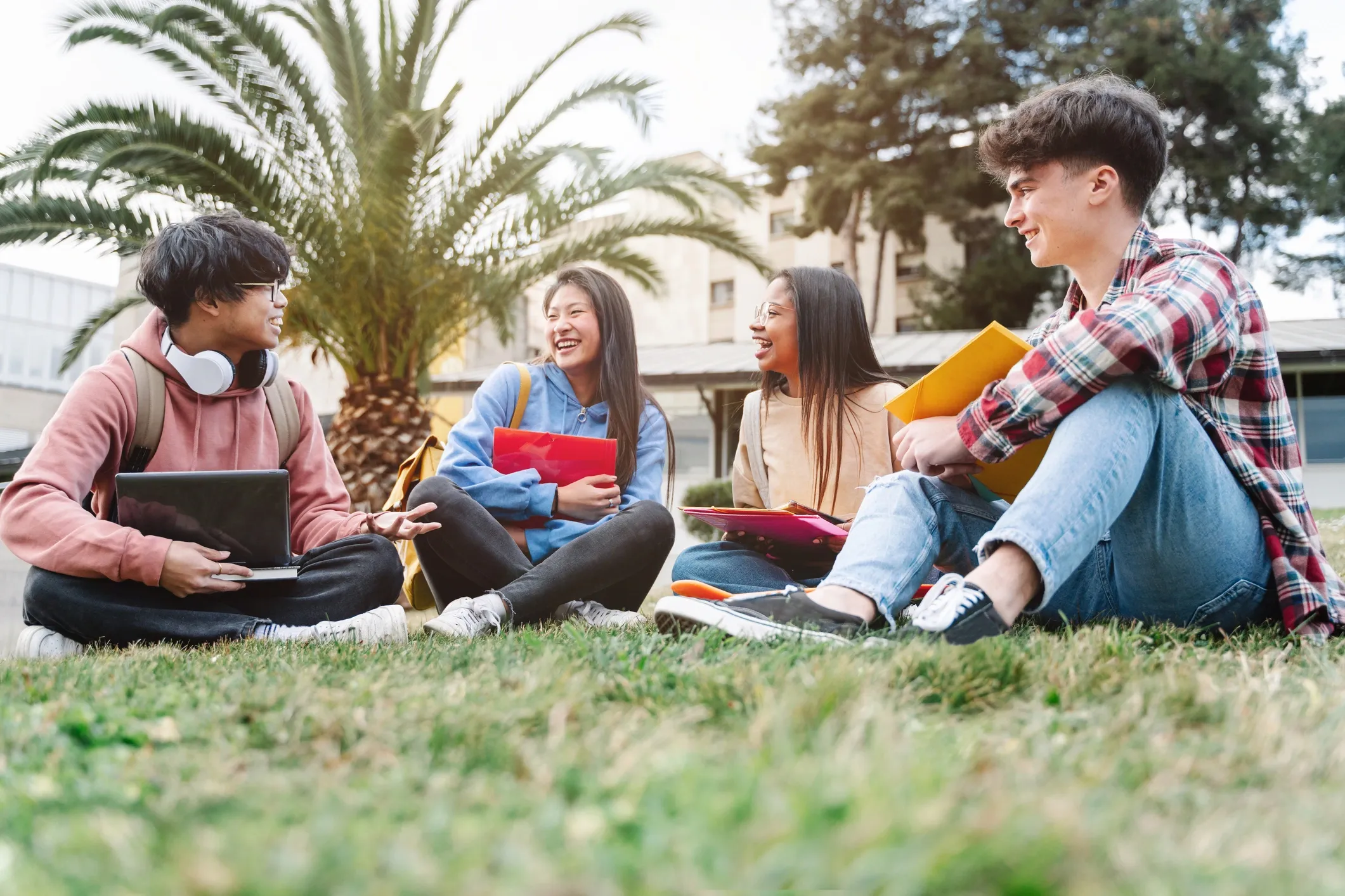 Smiling group of students sitting on grass